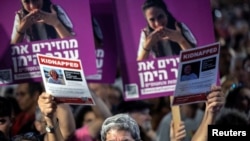 Участники демонстрации в Тель-Авиве с портретами заложников.