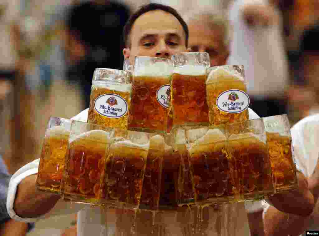 German Oliver Struempfl competes to set a new world record in carrying one liter beer mugs over a distance of 40 m (131 ft 3 in) in Abensberg.