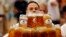 FILE - German Oliver Struempfl competes to set a new world record in carrying one liter beer mugs over a distance of 40 m (131 ft 3 in) in Abensberg, Sept. 7, 2014.