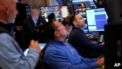 People work on the floor at the New York Stock Exchange in New York, March 4, 2025.