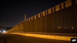 FILE - A portion of the new steel border fence stretches along the U.S.-Mexico border in Sunland Park, New Mexico, March 30, 2017.