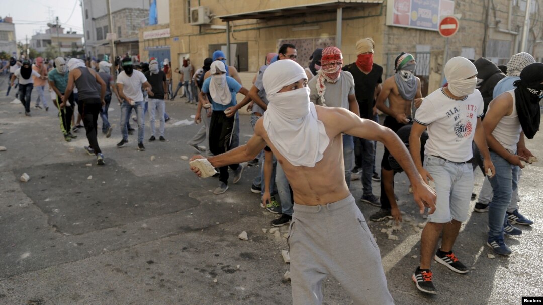 Para demonstran Palestina melemparkan batu ke arah pasukan keamanan Israel dalam protes di Shuafat, Yerusalem (5/10).