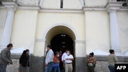 Personas salen de una misa en honor a las víctimas del nuevo coronavirus, en la iglesia San Vicente Mártir del municipio San Vicente Pacaya, a 45 kilómetros al sur de la Ciudad de Guatemala, el 15 de septiembre de 2020.