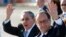 France's President Francois Hollande, right, and Cuba's President Raul Castro wave to reporters during Hollande's farewell ceremony at Jose Marti International Airport in Havana, May 12, 2015.