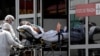 Trabajadores de la salud llevan en camilla a un paciente sospechoso de tener COVID-19 desde una ambulancia al hospital público HRAN en Brasilia, Brasil, el martes 23 de marzo de 2021.