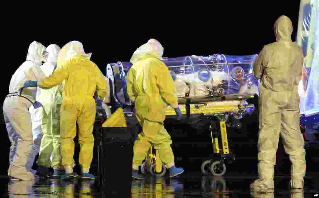 In this photo provided by the Spanish Defense Ministry, aid workers and doctors transfer Manuel Garcia Viejo, a Spanish priest who was diagnosed with the Ebola virus while working in Sierra Leone, from a military plane to an ambulance as he leaves the Torrejon de Ardoz military airbase, near Madrid.