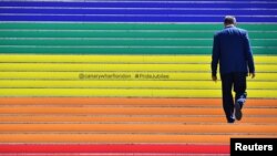 FILE - A man walks up a newly decorated staircase celebrating #PrideJubilee at Canary Wharf in London, Britain, July 1, 2019. 