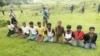 FILE - Ten Rohingya Muslim men with their hands bound kneel as members of the Myanmar security forces stand guard in Inn Din village, Sept. 2, 2017. 