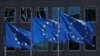 FILE - European Union flags flutter outside the European Commission headquarters in Brussels, Belgium, June 25, 2020. 