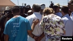 Jewish settlers speak to the media after leaving their homes in the West Bank outpost of Migron September 2, 2012.