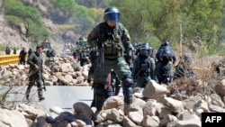 Policías bolivianos limpian una carretera bloqueada por simpatizantes del expresidente Evo Morales en Parotani, el 1 de noviembre de 2024. (AFP)