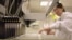 Researcher loads patient samples into a machine at Myriad Genetics, Salt Lake City, undated file image.