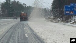 Petugas membersihkan jalanan dari salju di York County, South Carolina hari Minggu (16/1). 