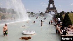 People cool off in the Trocadero fountains across from the Eiffel Tower in Paris as a heatwave hit much of the country, France, June 25, 2019.