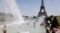 Парижани і туристи у фонтанах Трокадеро біля Ейфелевої вежі у столиці Франції 25 червня 2019 р.