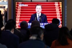 People watch a TV screen showing the live broadcast of South Korean President Moon Jae-in's New Year's speech at the Seoul Railway Station in Seoul, Jan. 7, 2020.