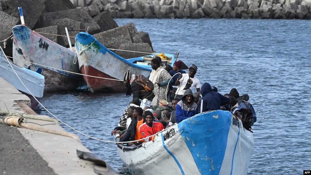 FILE - Migrants sit in a boat, after the Spanish Salvamento Maritimo (Sea Search and Rescue agency) vessel "Salvamar Adhara" rescued around 250 migrants in three different boats at sea, at La Restinga port, on the Canary Island of El Hierro, on February 4, 2023