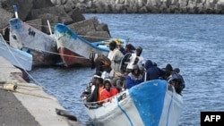 FILE - Migrants sit in a boat, after the Spanish Salvamento Maritimo (Sea Search and Rescue agency) vessel "Salvamar Adhara" rescued around 250 migrants in three different boats at sea, at La Restinga port, on the Canary Island of El Hierro, on February 4, 2023