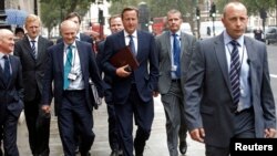 Britain's Prime Minister David Cameron (C) walks to Parliament after leaving Number 10 Downing Street in London Sep. 1, 2014.