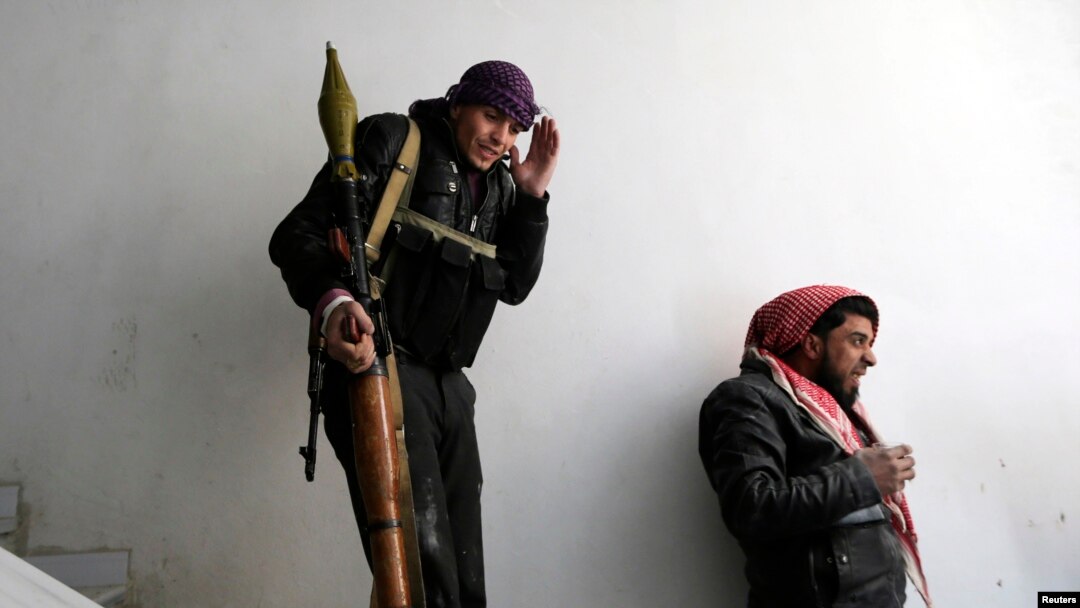 A fighter from the Sadik unit of Free Syrian Army's Tahrir al Sham brigade reacts as a missile fired by Syrian air force jet explodes near by during heavy fighting in Mleha suburb of Damascus, Jan. 22, 2013. 