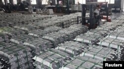 FILE - A worker drives a forklift to transport aluminum bars at a factory in Anshun, Guizhou province, China, July 1, 2013. 