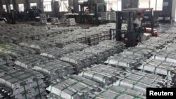 FILE - A worker drives a forklift to transport aluminum bars at a factory in Anshun, Guizhou province, China, July 1, 2013. 