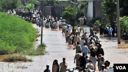 Warga Pakistan dengan membawa barang seadanya mengungsi dari kawasan banjir di Pakistan barat laut.