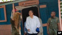 U.N. Secretary-General Ban Ki-moon walks out after visiting the house of a cholera victim during the launching of sanitation campaign in Hinche, Haiti, July 14, 2014. 