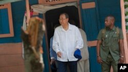 U.N. Secretary-General Ban Ki-moon walks out after visiting the house of a cholera victim during the launching of sanitation campaign in Hinche, Haiti, July 14, 2014. 
