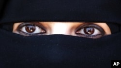 A veiled woman takes part in a protest calling on Syria's President Bashar Assad to step down, in front of the United Nations headquarters in Amman, on May 21, 2011.