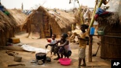 FILE - Families living in a refugee camp prepare food in Kaga-Bandoro, Central African Republic, Tuesday Feb. 16, 2016. 