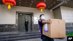 A FedEx employee removes a box from the Chinese Consulate Thursday, July 23, 2020, in Houston. 