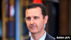 FILE - Syrian President Bashar al-Assad give an interview in Damascus, 25 Sept. 2015. Speaking with Russia's state-owned RIA Novosti news agency Wednesday, he said the international talks in Geneva should result in a government that includes both opposition representatives and officials loyal to his regime.