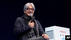 FILE - Japanese composer Ryuichi Sakamoto, speaks at the 'Nissan Leaf The New Owner's Meeting' in Tokyo on March 18, 2012.