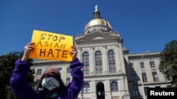 A person holds a placard during a "Stop Asian Hate" rally, following deadly shootings in the area, in Atlanta, March 20, 2021. 