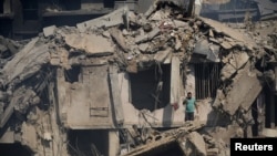 A civil defense worker stands amid damage in the aftermath of what security sources said was an Israeli strike on a market in Nabatieh, Lebanon, on Oct. 13, 2024.