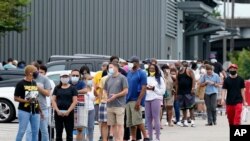 En una tienda de la cadena mayorista Costco, en Nueva Orleans, se extiende una larga fila de personas que buscan provisiones el domingo 23 de agosto de 2020, mientras se acerca Marco a la costa sur de Lousiana.