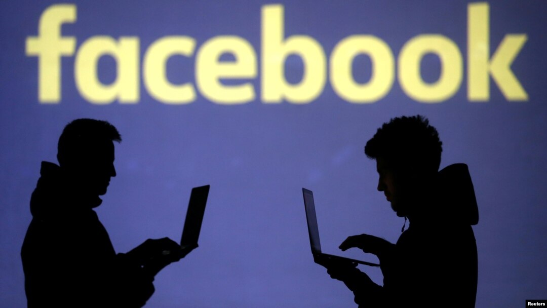 Silhouette dari pengguna laptop tampak di muka proyeksi logo Facebook di layar dalam gambar ilustrasi yang diambil tanggal 28 Maret 2018 (foto: REUTERS/Dado Ruvic/Ilustrasi)
