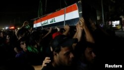 Warga Irak mengangkut jenazah demonstran yang tewas dalam aksi protes anti pemerintah di Baghdad, Irak (10/4). 