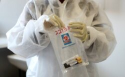 FILE - A health worker holds a COVID-19 sample collection kit of a vaccine trial volunteer, after a test for the coronavirus disease, at the Wits RHI Shandukani Research Centre in Johannesburg, South Africa, Aug. 27, 2020.