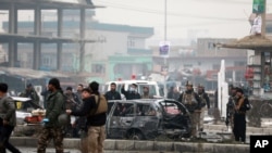 Afghan security personnel inspect the site of a bombing attack in Kabul, Afghanistan, Dec. 20, 2020.
