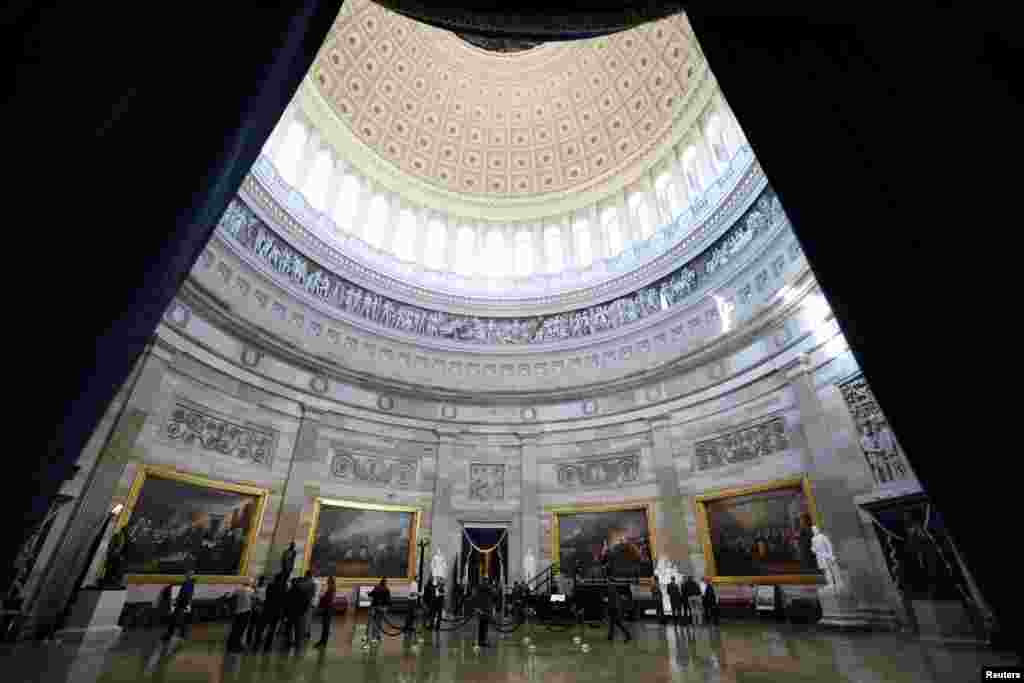 People stand in the rotunda where the inaugural address will take place after it was announced President-elect Donald Trump&#39;s inauguration is being moved indoors due to dangerously cold temperatures expected on Monday, in Washington.