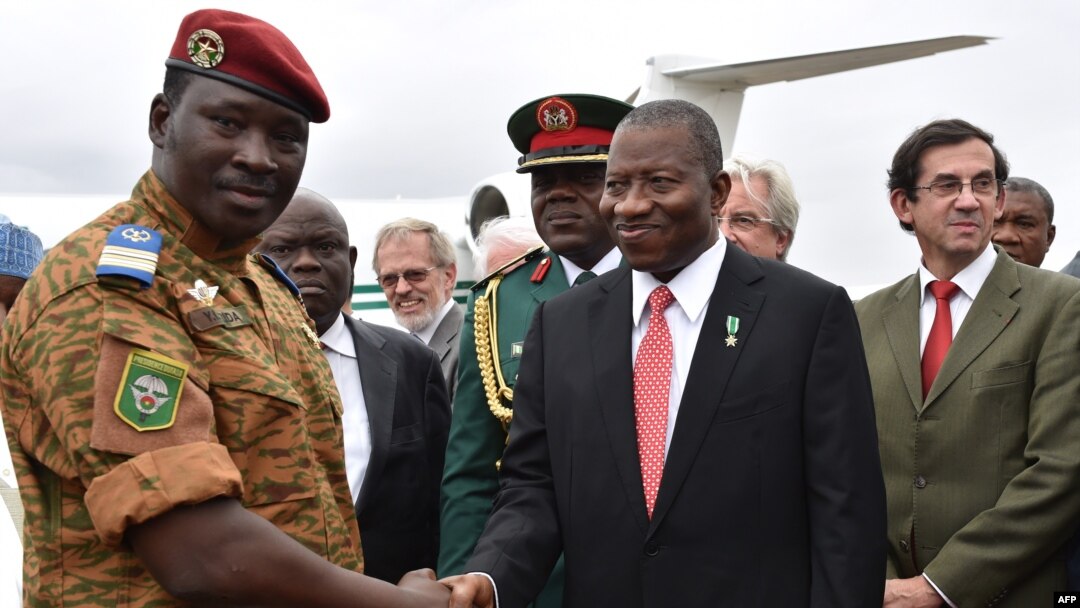 Burkina Faso's Lieutenant Colonel Isaac Zida (L) welcomes Nigerian President Goodluck Jonathan (C) next to French Ambassador Gilles Thibault (R) upon their arrival at Ouagadougou airport, Nov. 5, 2014. 