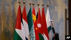 资料照片：中国外长王毅在北京钓鱼台国宾馆与阿拉伯和伊斯兰国家外长代表团举行会议前，工作人员在擦拭各方旗帜。(2023年11月20日)