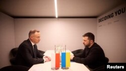 FILE - Ukraine's President Volodymyr Zelenskiy and Poland's President Andrzej Duda attend a meeting during the World Economic Forum in Davos, Switzerland January 16, 2024.
