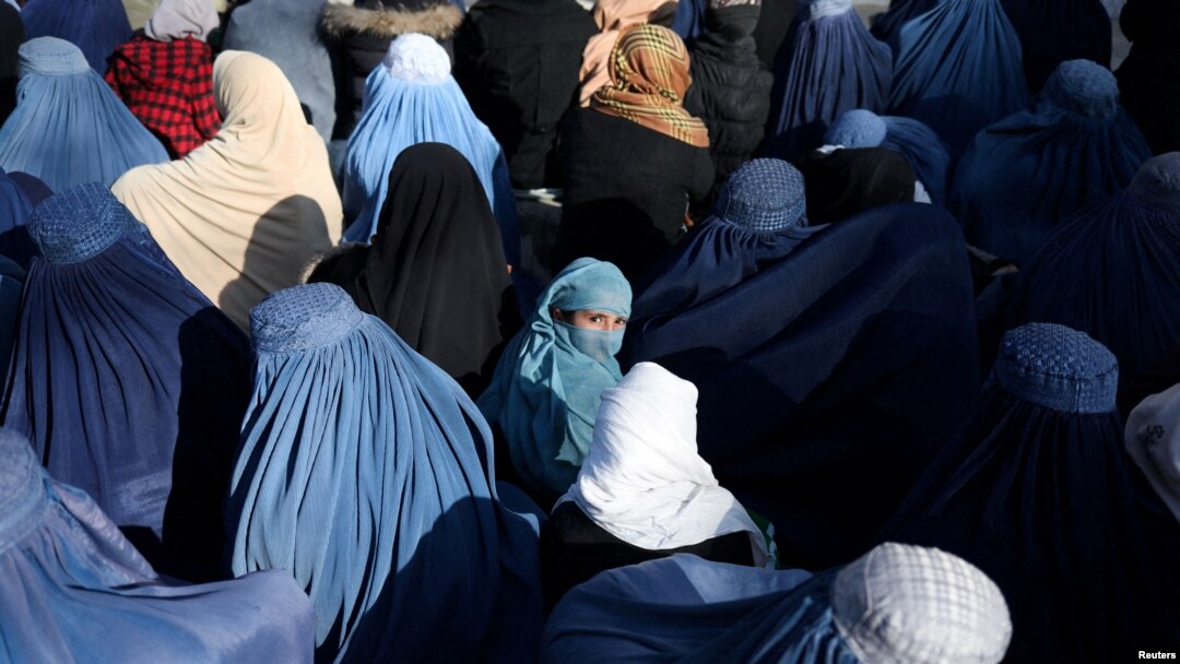 People wait to receive bread in Kabul