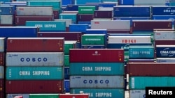 FILE PHOTO: A truck carrying containers are seen near a Chinese flag at the Yangshan Deep Water Port in Shanghai, China August 6, 2019. REUTERS/Aly Song/File Photo