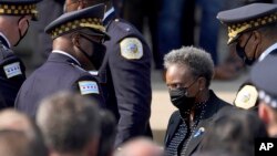 FILE - Chicago mayor Lori Lightfoot, right, and Police Superintendent David Brown, center left, assemble outside a funeral service for a police officer killed in the line of duty, Aug. 19, 2021, in Chicago.