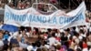 Pope Francis is driven through the crowd as a large banner reading "Let's renew the church" is visible in the foreground, in Palermo, Italy, Sept. 15, 2018. Francis was paying tribute in Sicily to a priest who worked to keep youths away from the Mafia and was slain by mobsters.