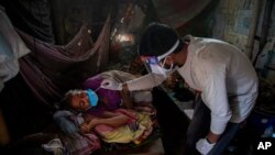 9일 인도 가우하티에서 보건 관계자가 집에 있는 노인의 신종 코로나바이러스 감염 검사를 위해 검체를 채취하고 있다.